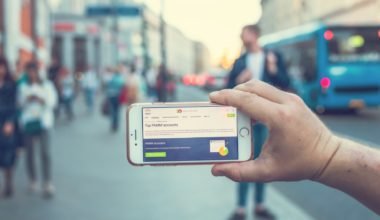 a person holding a white and gray smartphone